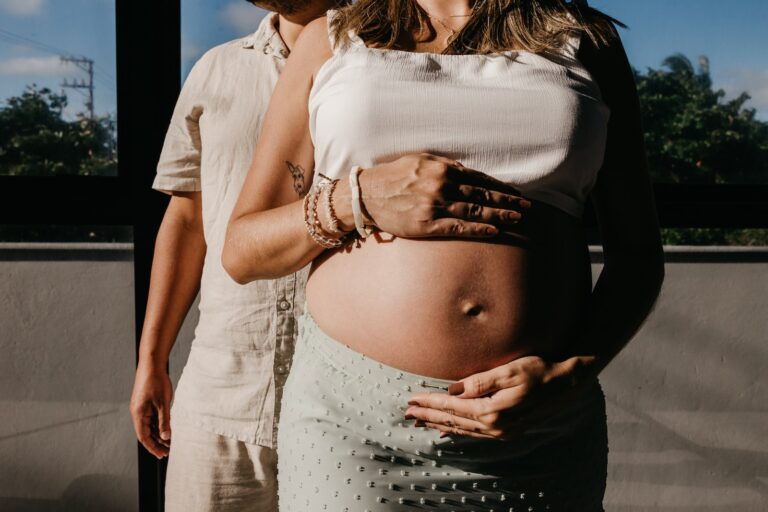 a pregnant woman standing next to a man